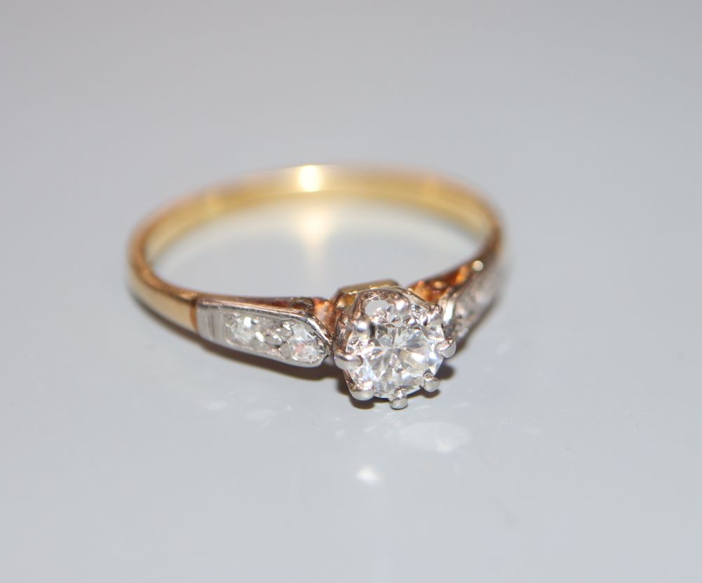 A yellow metal and single stone diamond ring, with diamond set shoulders, size O, gross 2.5 grams.
